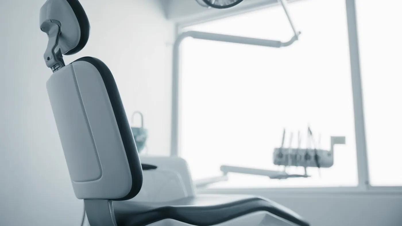 A modern dental treatment room, clean and calming by a bright window
